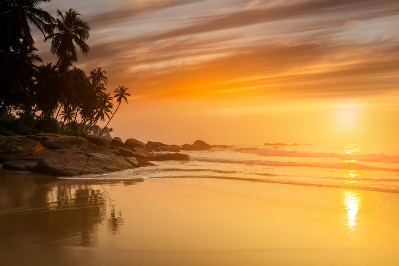 Sonnenuntergang mit Kokospalmen am Strand