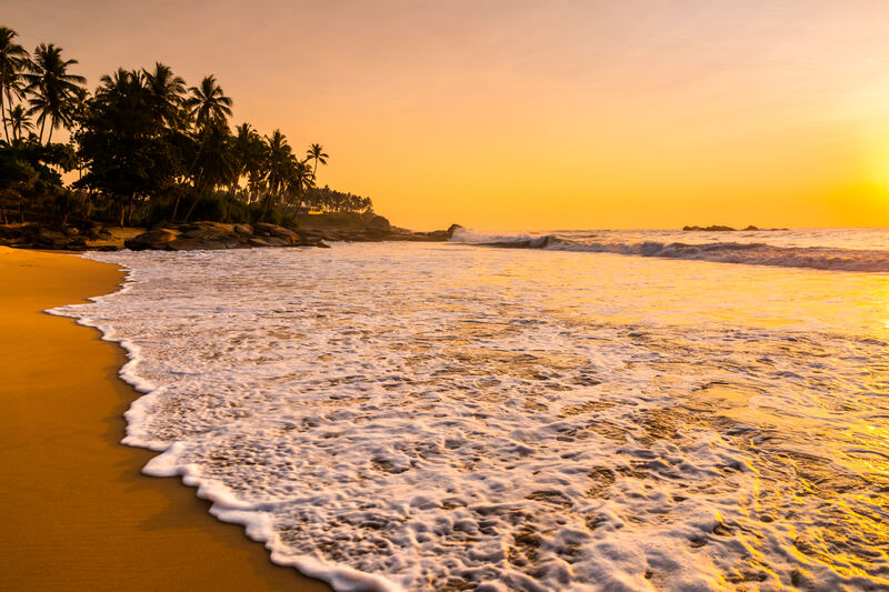 Romantischer Sonnenuntergang am Tropenstrand mit Palmen